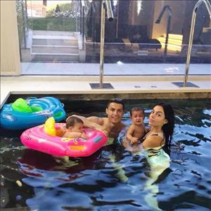 Ronaldo thư giãn trong bể bơi với bạn gái và con