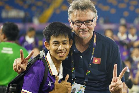 Tình nguyện viên SEA Games mừng rỡ vì được chụp ảnh với HLV Troussier