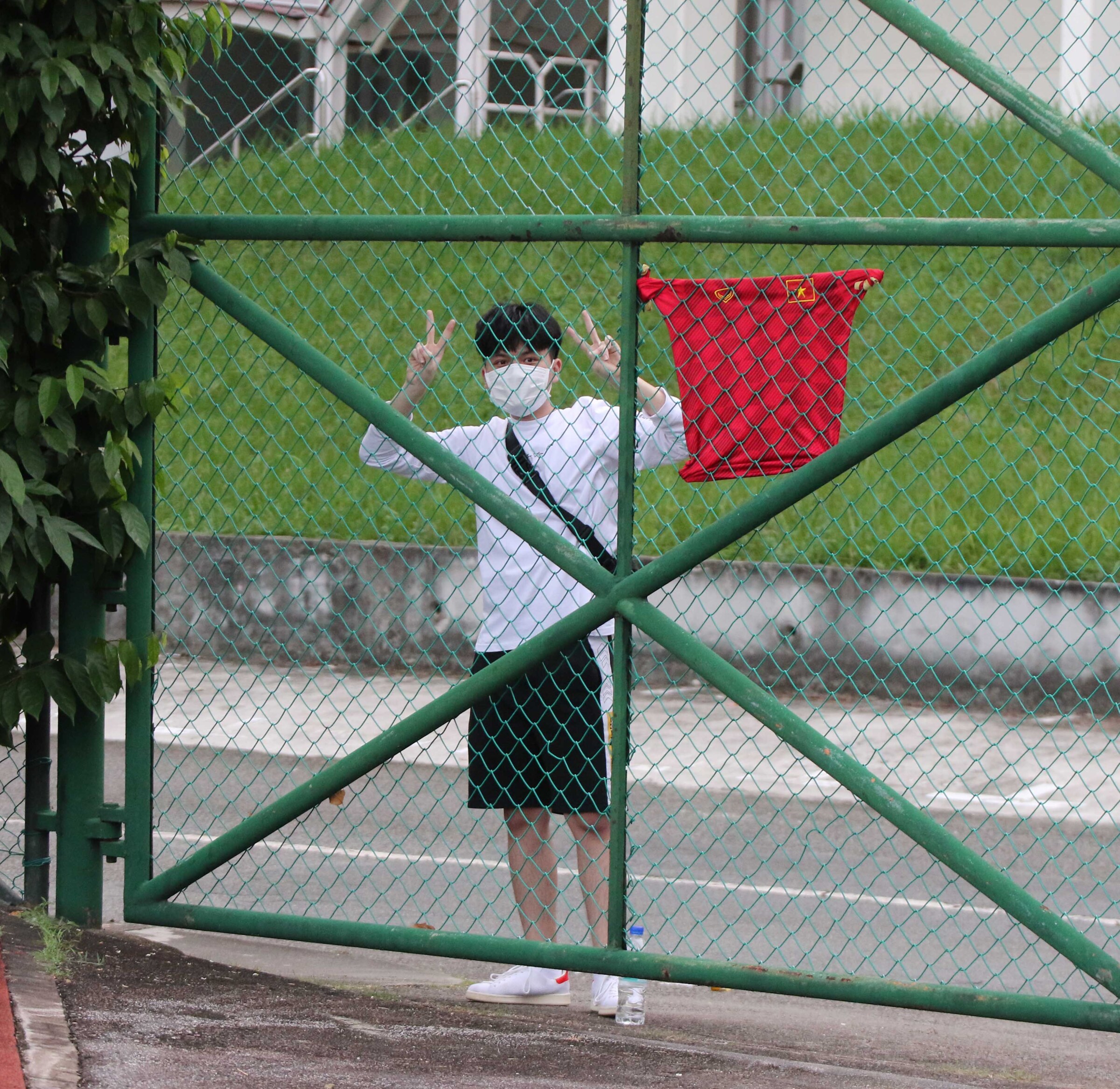 Một người hâm mộ đứng ngoài hàng rào xem ĐT Việt Nam tập