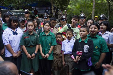 Hoc sinh dia phuong hat o hang Tham Luang khi chien dich cuu ho 13 nguoi dien ra hom 4/7. Anh: AFP